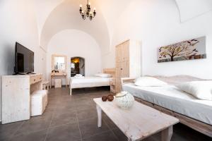 a living room with two beds and a table at Villa Aegeon Grande in Megalochori