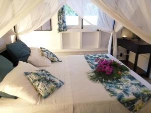 Un dormitorio con una cama con flores. en Blue Kaz Caraïb, en Pointe-Noire
