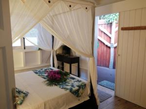 - une chambre avec un lit fleuri dans l'établissement Blue Kaz Caraïb, à Pointe-Noire