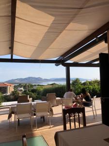 a patio area with chairs, tables and umbrellas at Amaremare B&B in Stintino