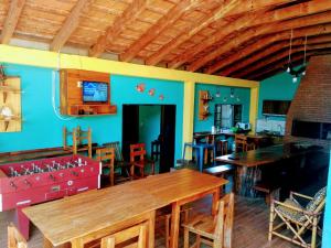 伊泰普蘭迪亞的住宿－Pousada Don Blu，一间拥有蓝色墙壁和木桌及椅子的用餐室