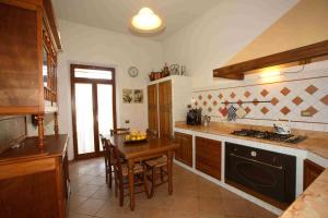 a kitchen with a table and a stove top oven at Villa Il Colle di Monteaperti in Casetta +6 photos