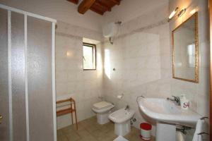 a white bathroom with a toilet and a sink at Villa Il Colle di Monteaperti in Casetta