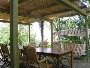a wooden table and chairs under a wooden pergola at Villa Il Colle di Monteaperti in Casetta