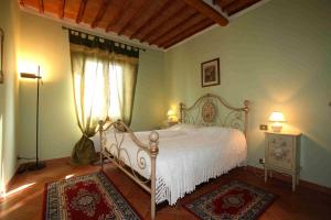 a bedroom with a white bed in a room with rugs at Villa Il Colle di Monteaperti in Casetta