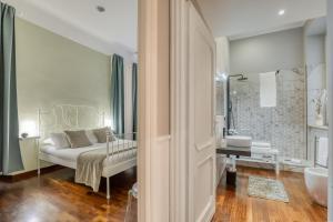 a bedroom with a bed and a bathroom with a tub at ATRHOME Frattina Luxury in Rome +16 photos