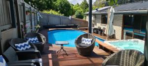 a deck with chairs and a swimming pool at Coronet View Accommodation in Queenstown