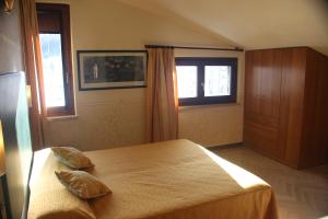 a bedroom with a bed with two pillows on it at Albergo Sole in San Zeno di Montagna