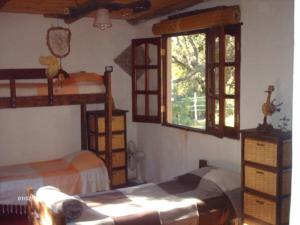a bedroom with two bunk beds and a window at Giramundo Hostel y Posada Eco-Cultural in San Marcos Sierras