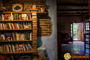 a book shelf filled with books in a room at Giramundo Hostel y Posada Eco-Cultural in San Marcos Sierras