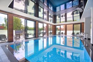 a large swimming pool in a house with windows at Savana Resort Mielno in Mielno