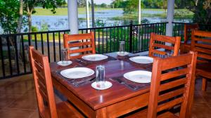 uma mesa de madeira com cadeiras e pratos em Double Lake View Tissa & Safari em Tissamaharama