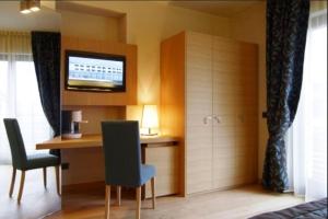 Zimmer mit einem Schreibtisch, Stühlen und einem TV in der Unterkunft Hotel Natura in Castel di Sangro