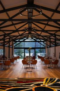 uma grande sala com mesas, cadeiras e janelas em Marramarra Lodge em Bar Point