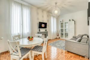 een woonkamer met een tafel en een bank bij ATRHOME penthouse Frattina in Rome