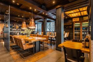 une salle à manger avec des tables et des chaises en bois dans l'établissement Hotel Zeezicht, à Oost-Vlieland