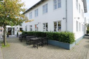 een groep tafels en stoelen voor een gebouw bij Hotel Hjallerup Kro in Hjallerup