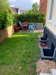 a backyard with a table and chairs and a grill at Wohnung Frida in Pinneberg