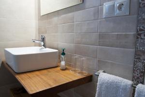 een badkamer met een witte wastafel op een houten aanrecht bij Apartamentos Rurales Camín Real in La Caridad