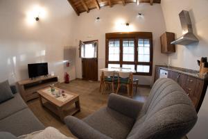 a living room with a couch and a table at Apartamentos Rurales Camín Real in La Caridad +10 photos