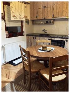 a kitchen with a wooden table with chairs and a sink at Vila Jelena, Tara in Kaludjerske Bare