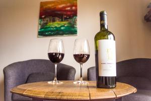 una bottiglia di vino seduta su un tavolo con due bicchieri da vino di Independencia Square Viewpoint a Mendoza