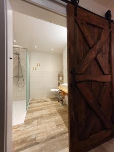 a bathroom with a sliding barn door and a shower at Gasthaus zum Hirschen in Furtwangen