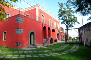 ein rotes Gebäude mit einer Treppe davor in der Unterkunft Palazzo Rosso in Riposto