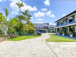 a cobblestone driveway in front of a house at Ala Moana Pousada in Bombinhas