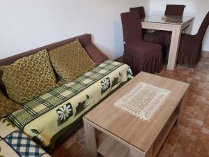 una sala de estar con un sofá y una mesa en Zlatiborsko jutro 1, en Zlatibor