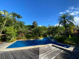 - une piscine dans un complexe avec des palmiers dans l'établissement Villa Bebek Hotel, à Camburi