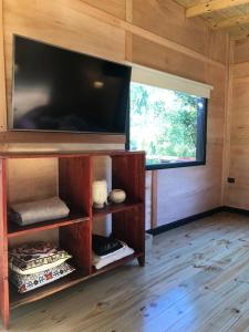 a living room with a large flat screen tv on the wall at Eco Cabaña Río - Cabaña Mirador in Tigre