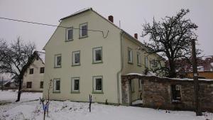 a yellow house with snow on the ground at Urlaub auf dem Bauernhof,Landurlaub,Ferienwohnung in Gränze +4 photos