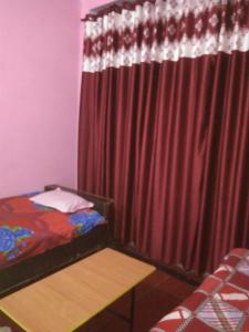 a bedroom with a bed and a red curtain at K.S.N. Varanasi Paying Guest House in Varanasi