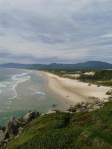 a view of a beach with rocks and the ocean at Canto da Cigarra I - Praia do Moçambique - FLORIANOPOLIS - SC in Florianópolis
