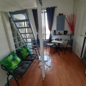 a living room with a couch and a staircase at Studio indépendant centre ville Aix les bains in Aix-les-Bains