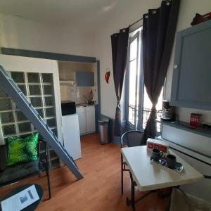 a living room with a staircase and a table at Studio indépendant centre ville Aix les bains in Aix-les-Bains