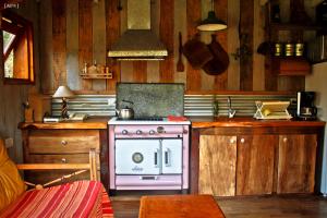 a kitchen with a pink stove and wooden cabinets at Bosque Peralta Ramos Cabañas Nalu 1 in Mar del Plata