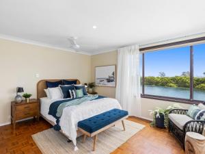 a bedroom with a bed and a large window at Watersedge in Currarong