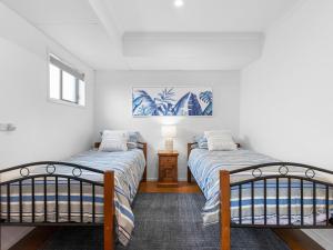 a bedroom with two beds and a window at Watersedge in Currarong +23 photos
