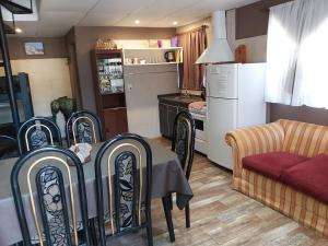 comedor con mesa y sillas y cocina en Apartamentos Esquiu en Mar del Plata