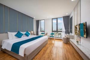 una camera da letto con un letto grande e una grande finestra di Calix Hotel Da Nang Beach a Da Nang