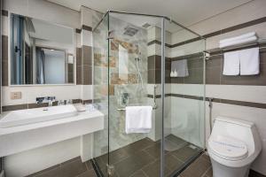 un bagno con doccia, WC e lavandino di Calix Hotel Da Nang Beach a Da Nang