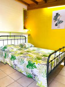 a bed in a room with a yellow wall at Studio avec jardin clos et wifi a Basse Terre in Basse-Terre