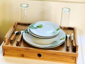 a wooden tray with plates and utensils on it at Studio avec jardin clos et wifi a Basse Terre in Basse-Terre