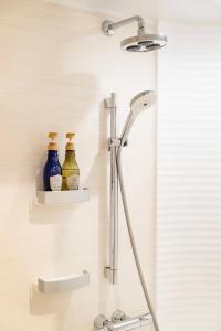 Chalet Villars في هاكوبا: رأس دش على جدار مع زجاجات على الأرفف