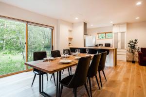 Chalet Villars في هاكوبا: غرفة طعام مع طاولة وكراسي خشبية