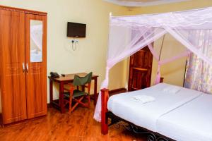 a bedroom with a bed and a desk with a computer at Bright Star Hotel in Arusha