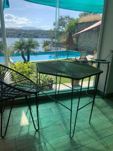 ein Tisch und Stühle in einem Zimmer mit Blick auf einen Pool in der Unterkunft Experiencia Teques in Tequesquitengo