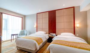 Pokój hotelowy z 2 łóżkami i krzesłem w obiekcie Yantai Meiya International ApartHotel (Previous Ramada Plaza) w mieście Yantai